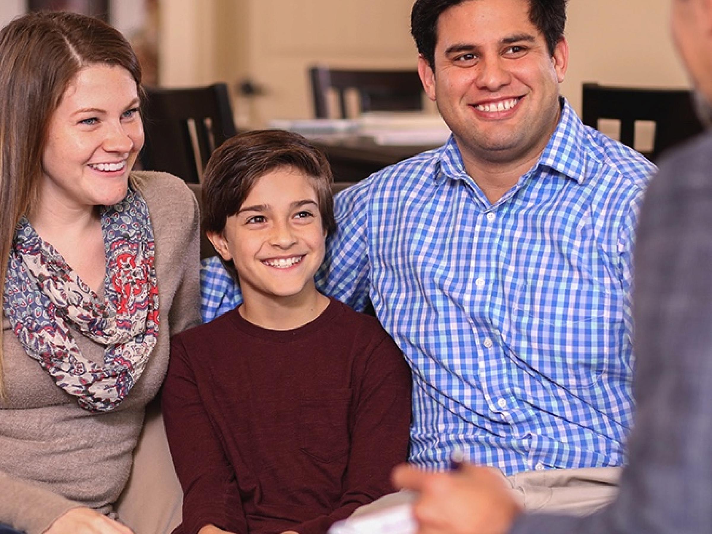 family smiling in therapy