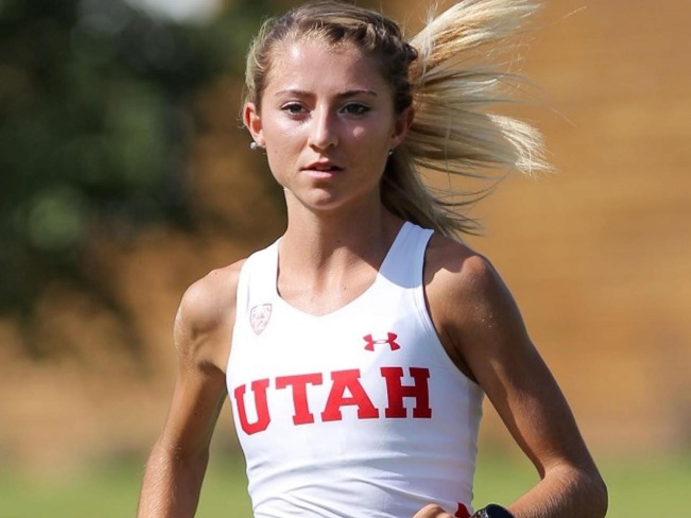 Grasyon Murphy running in a white tank top that says  "Utah" in red