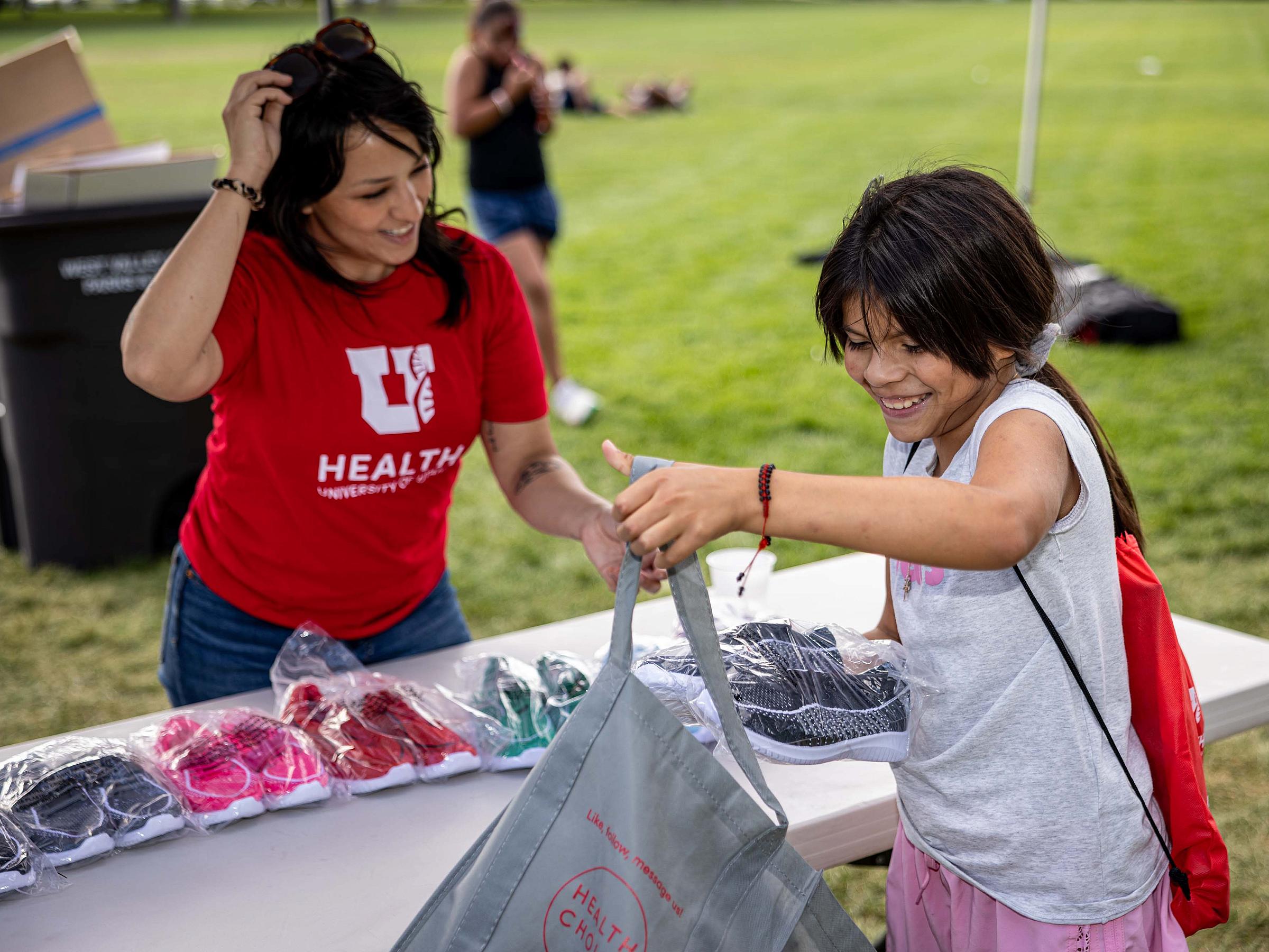 Child puts new shoes in a bag at the West Valley health fair