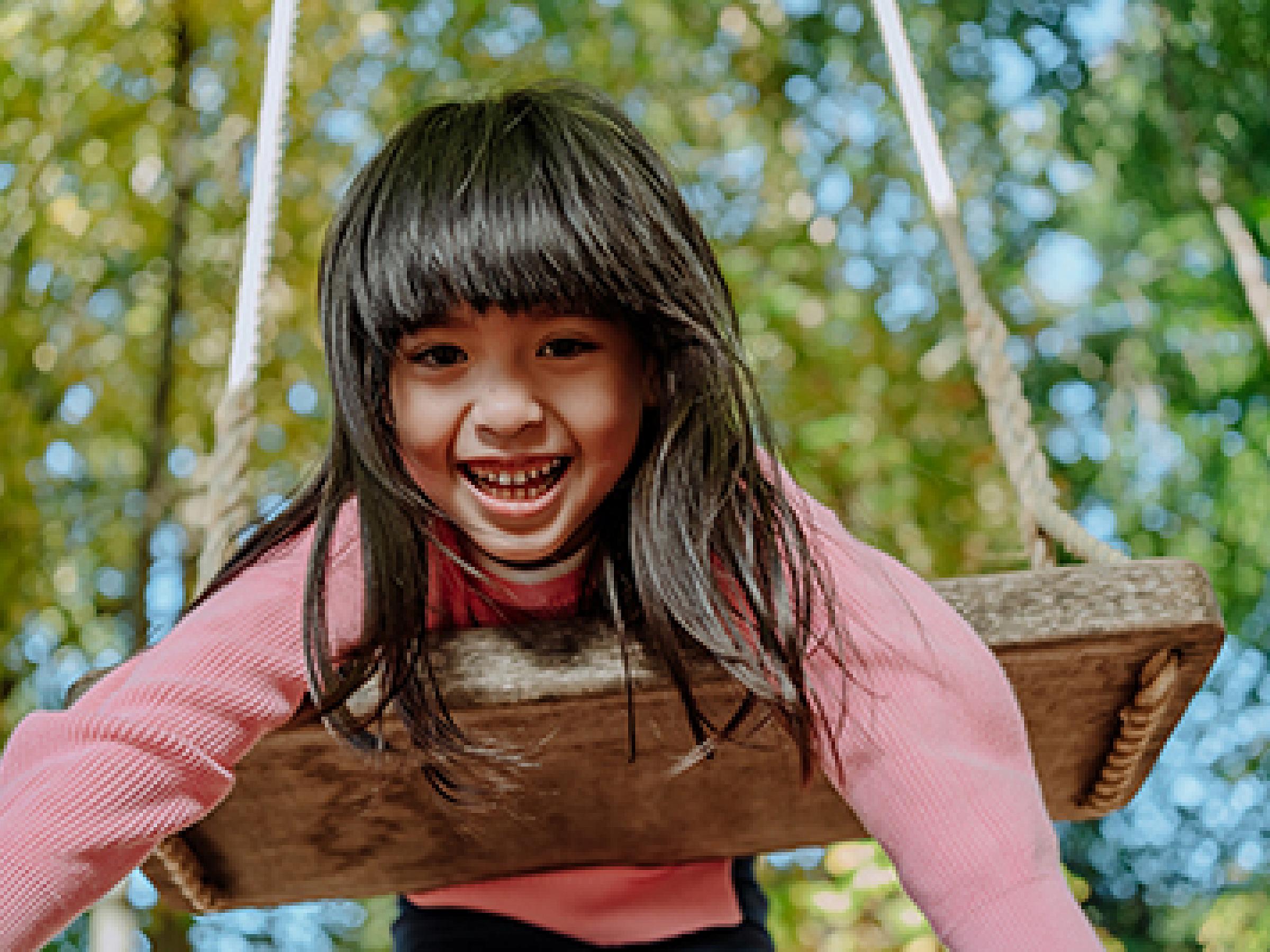 Young girl hanging on swing