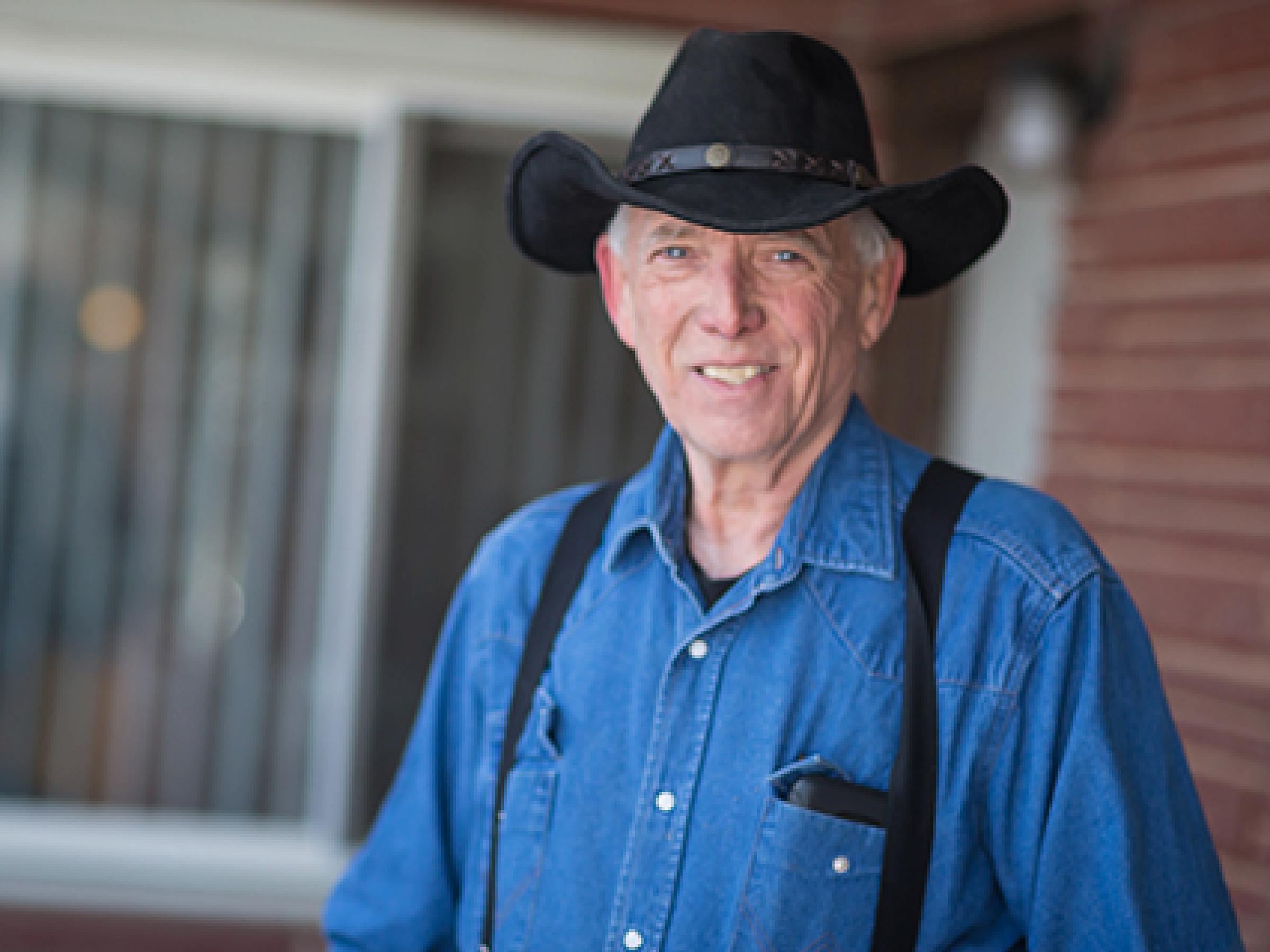 Mark Armstrong, focused ultrasound patient in front of window in red brick house