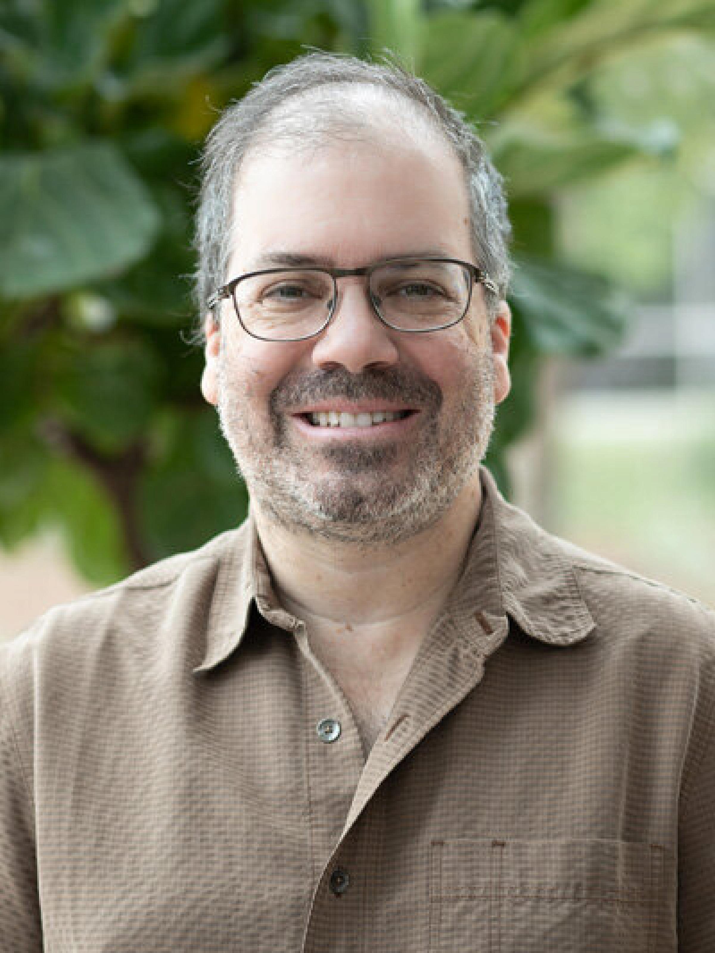Profile photo of a man in a brown shirt.