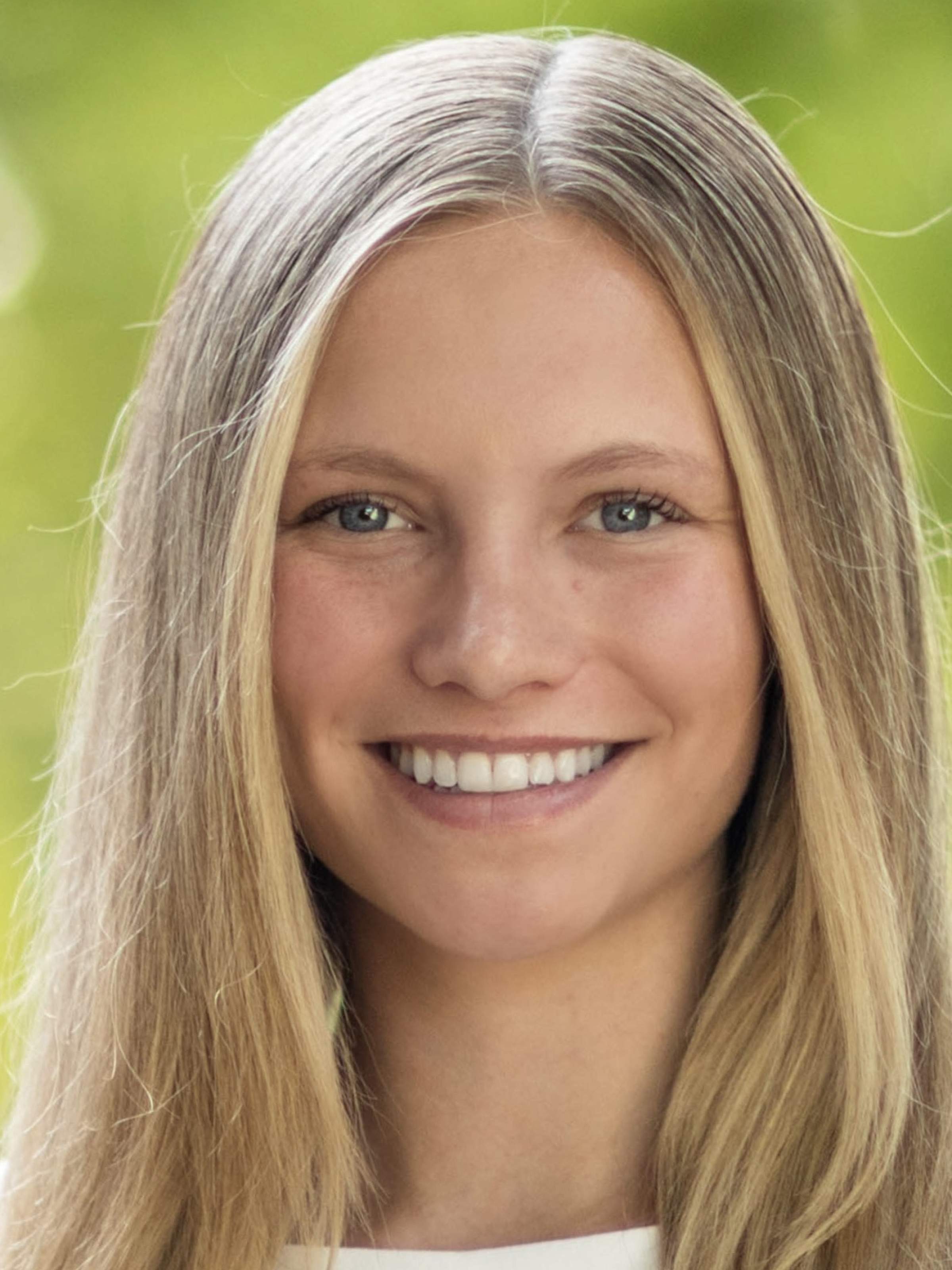A woman with long, straight, blonde hair smiles