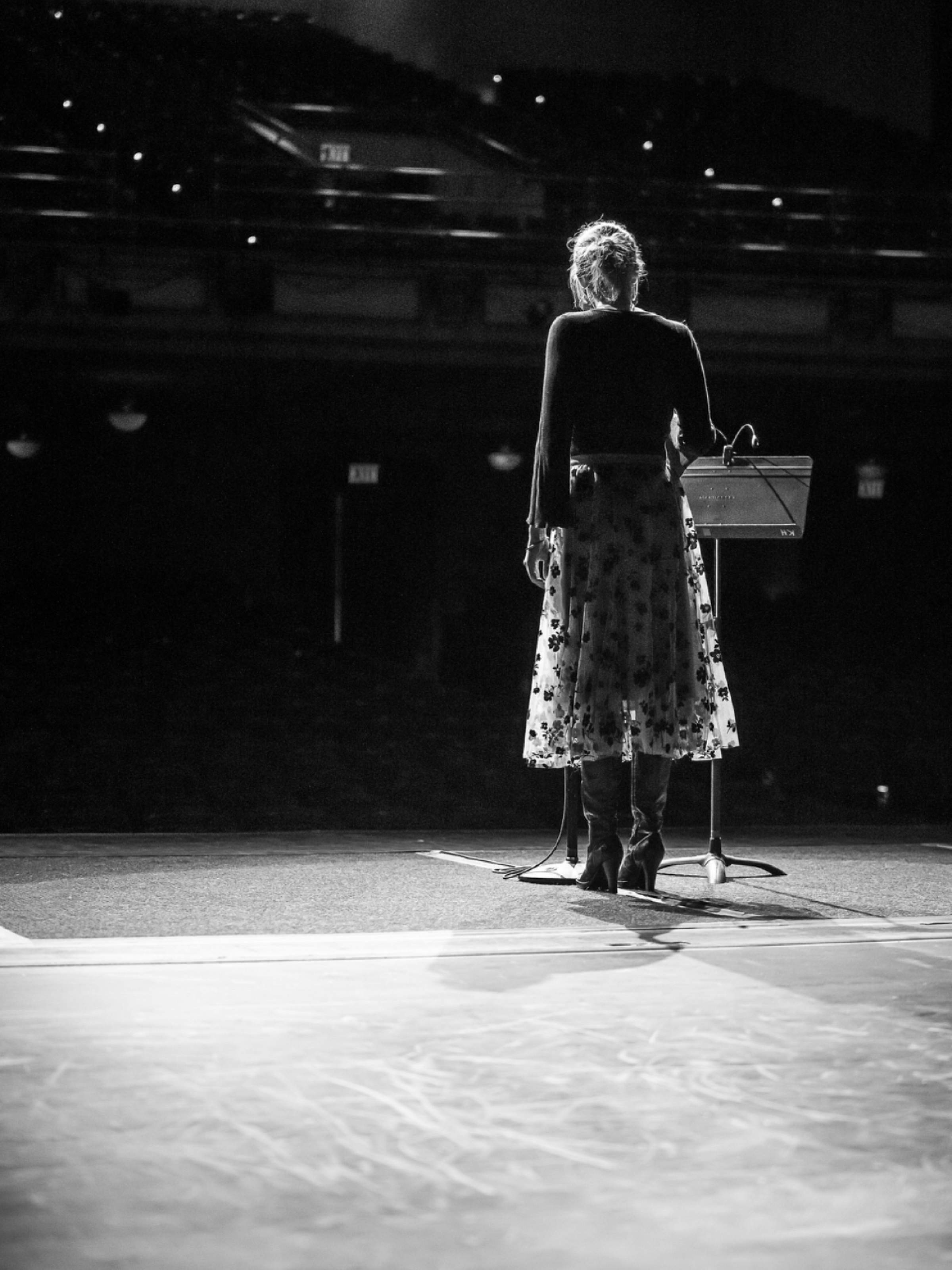 A woman standing on stage behind a microphone