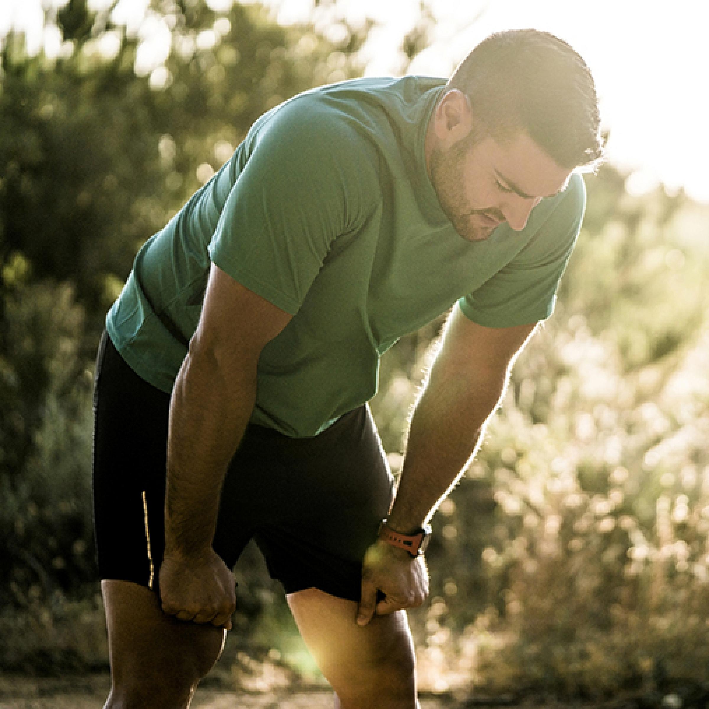 Male bent over tired after running