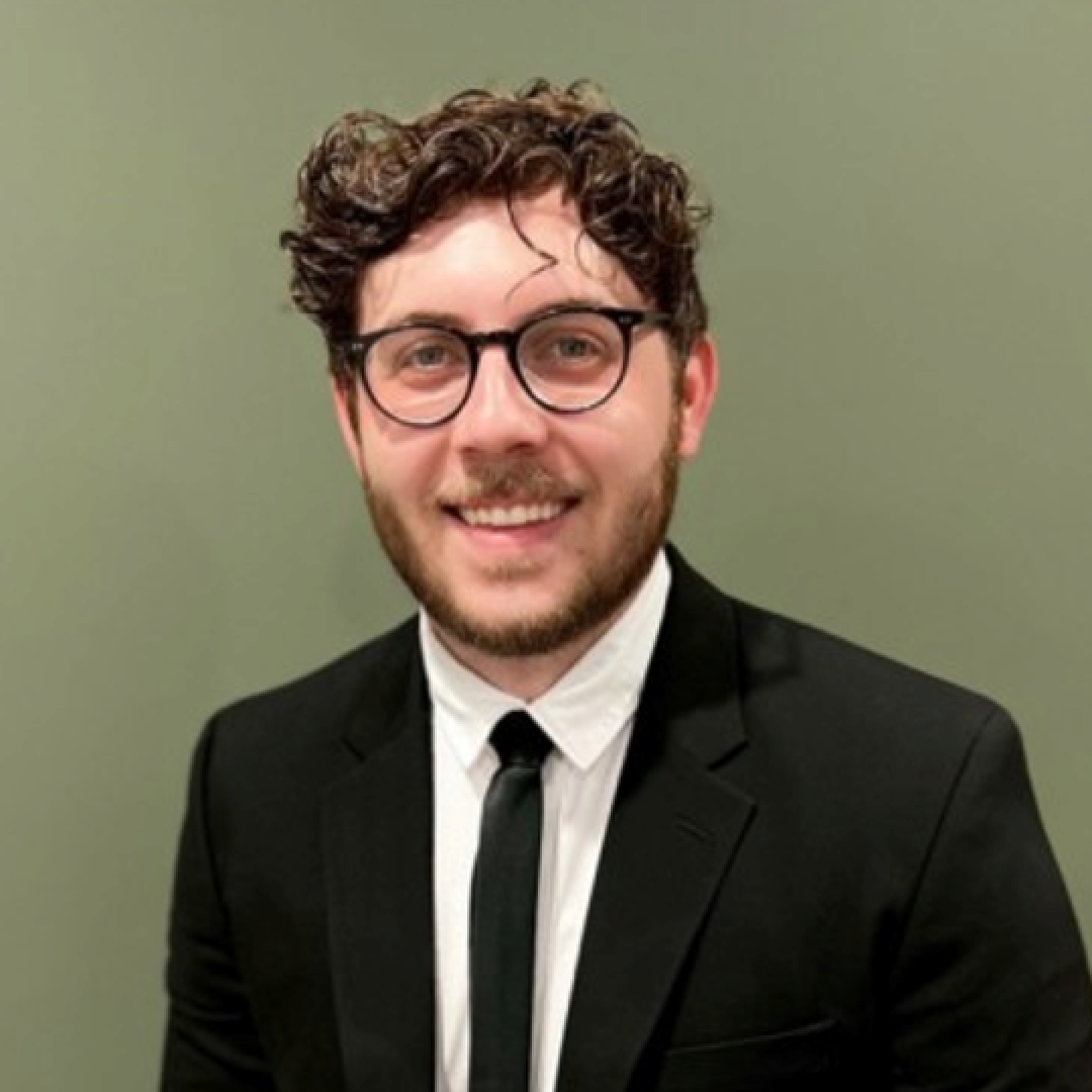 Timothy Clawson wears thick framed glasses and has short, curly brown hair.