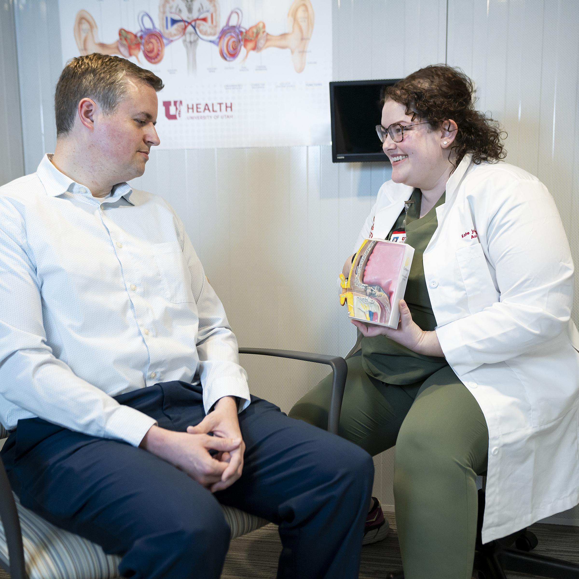 Audiologist Kate Johnson shows audiologist Nate Hendriksen a model of an ear canal.