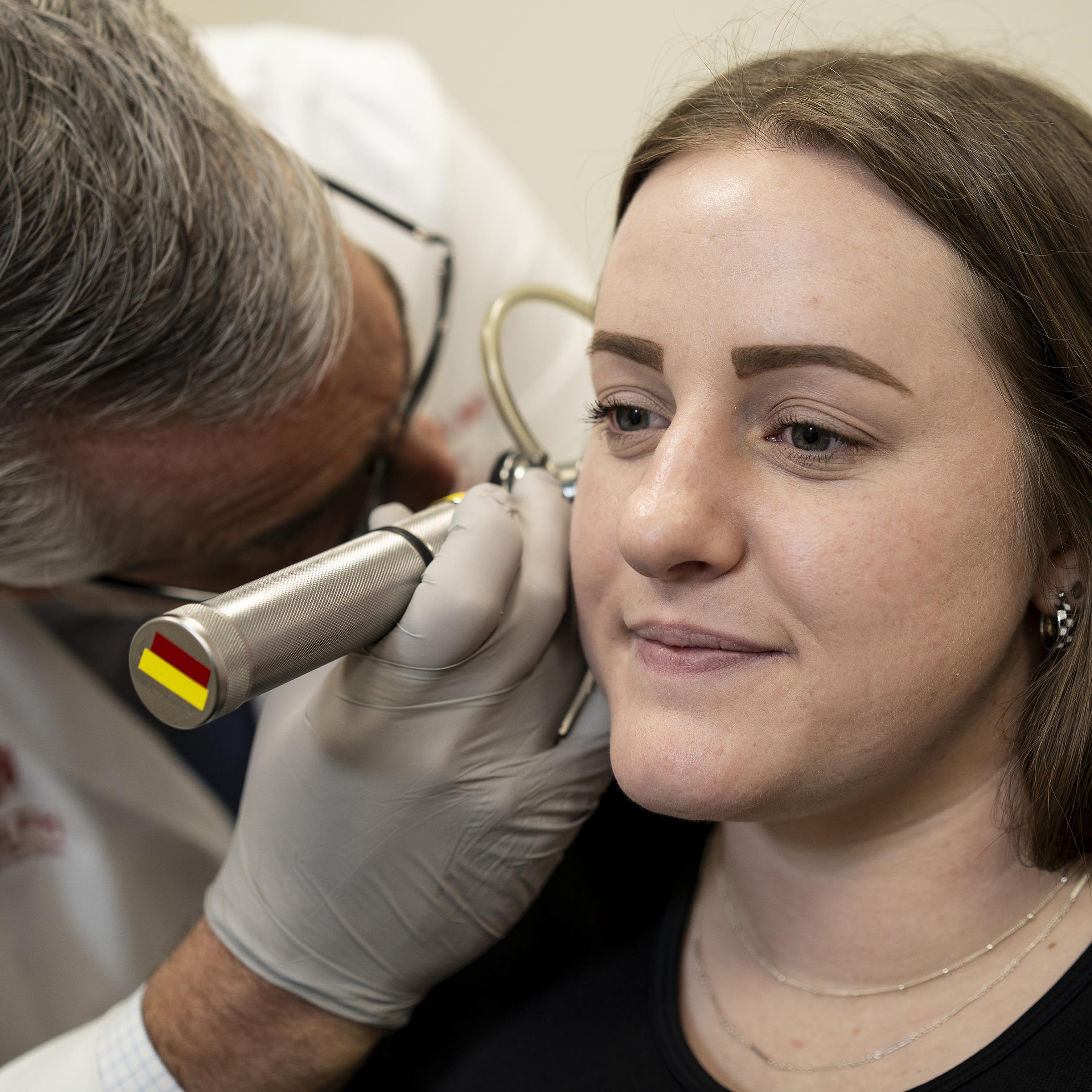 U of U health ENT doctor examines a female patient's ears