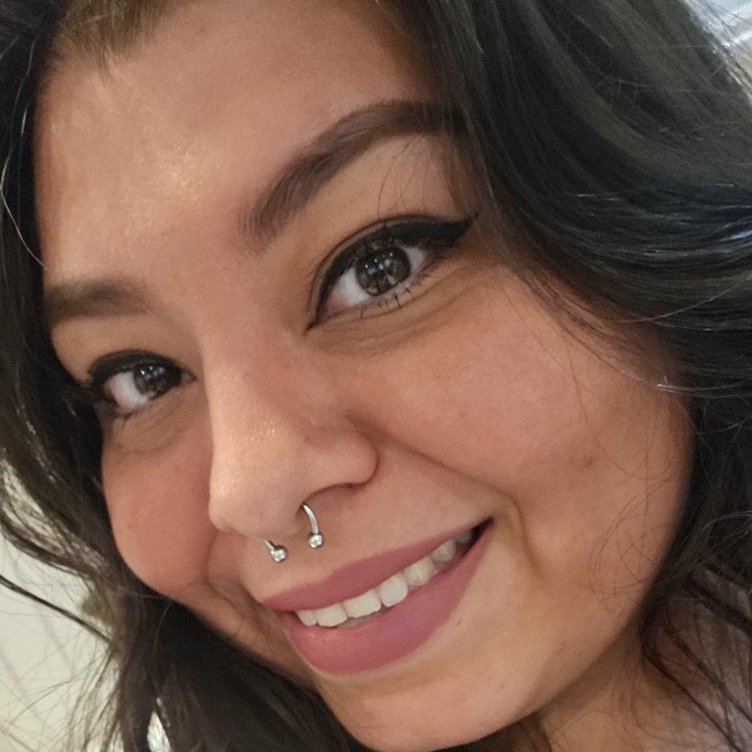 Jazmin Solorio has long dark curly hair and wears an orange shirt.