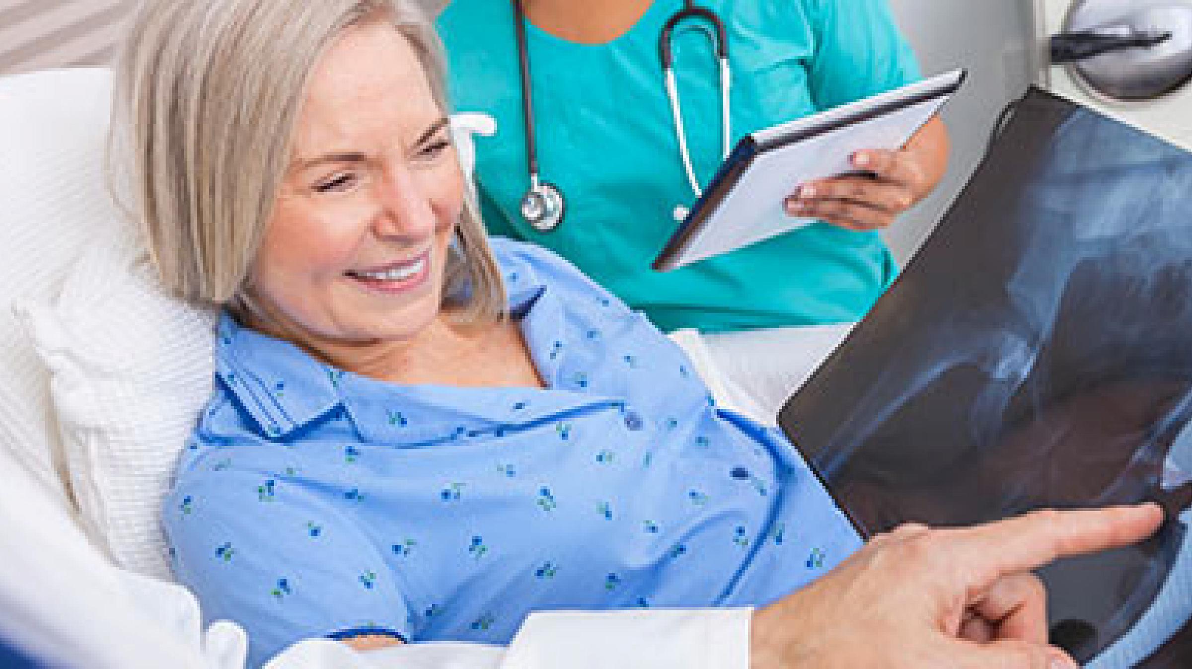 Woman in hospital bed looking at xrays