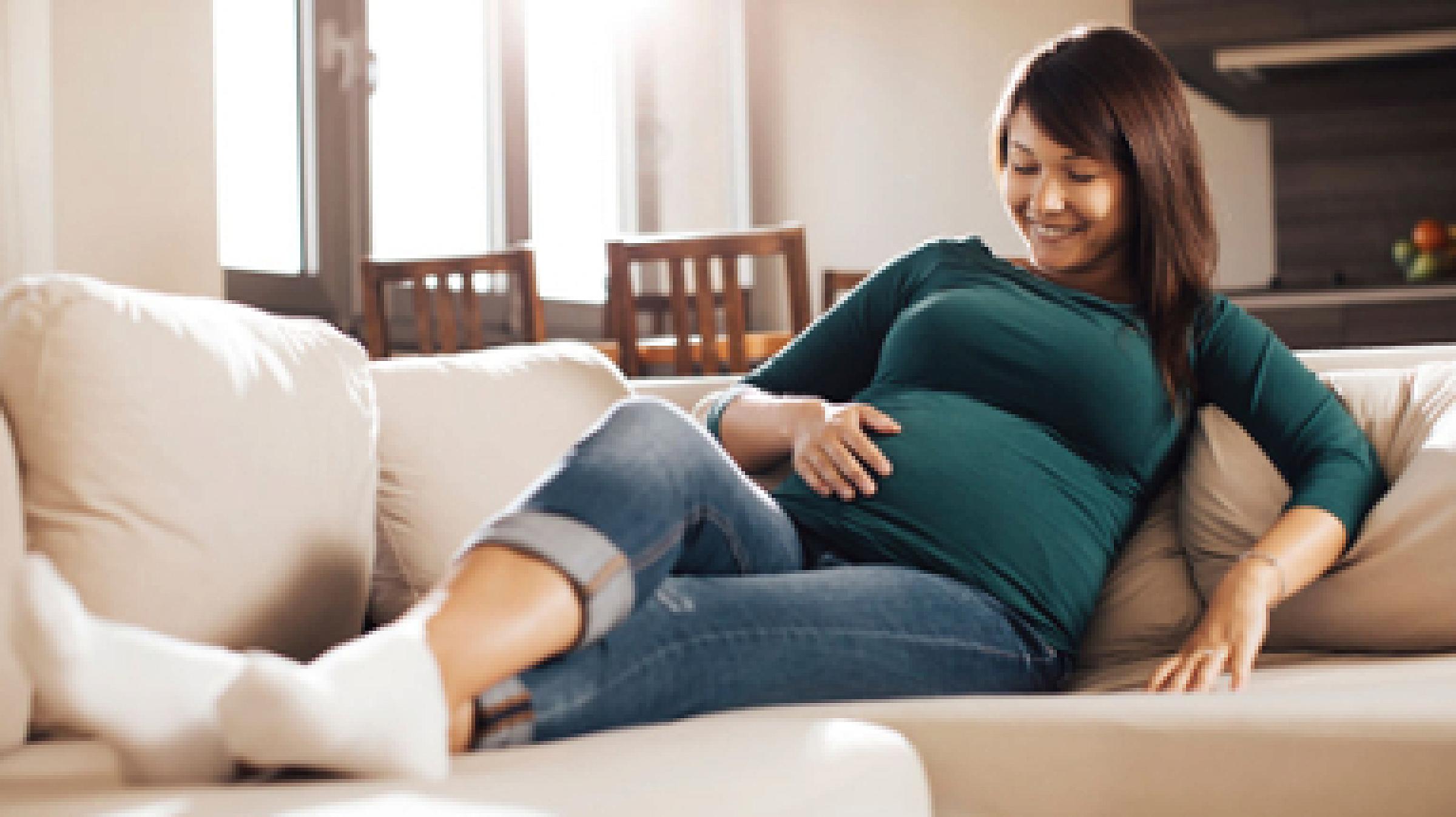 Pregnant white woman on couch