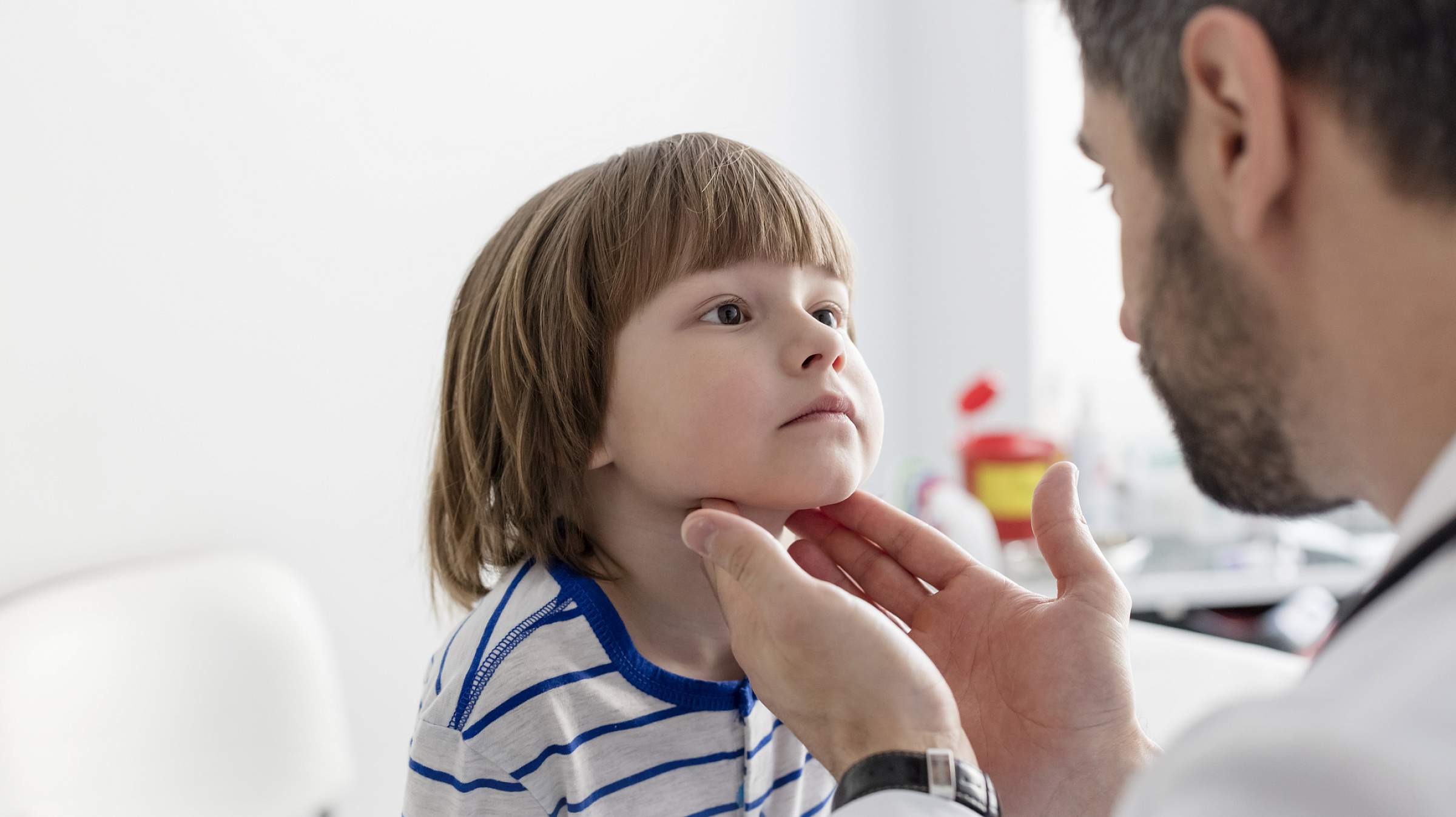 Child having their throat examined by a doctor