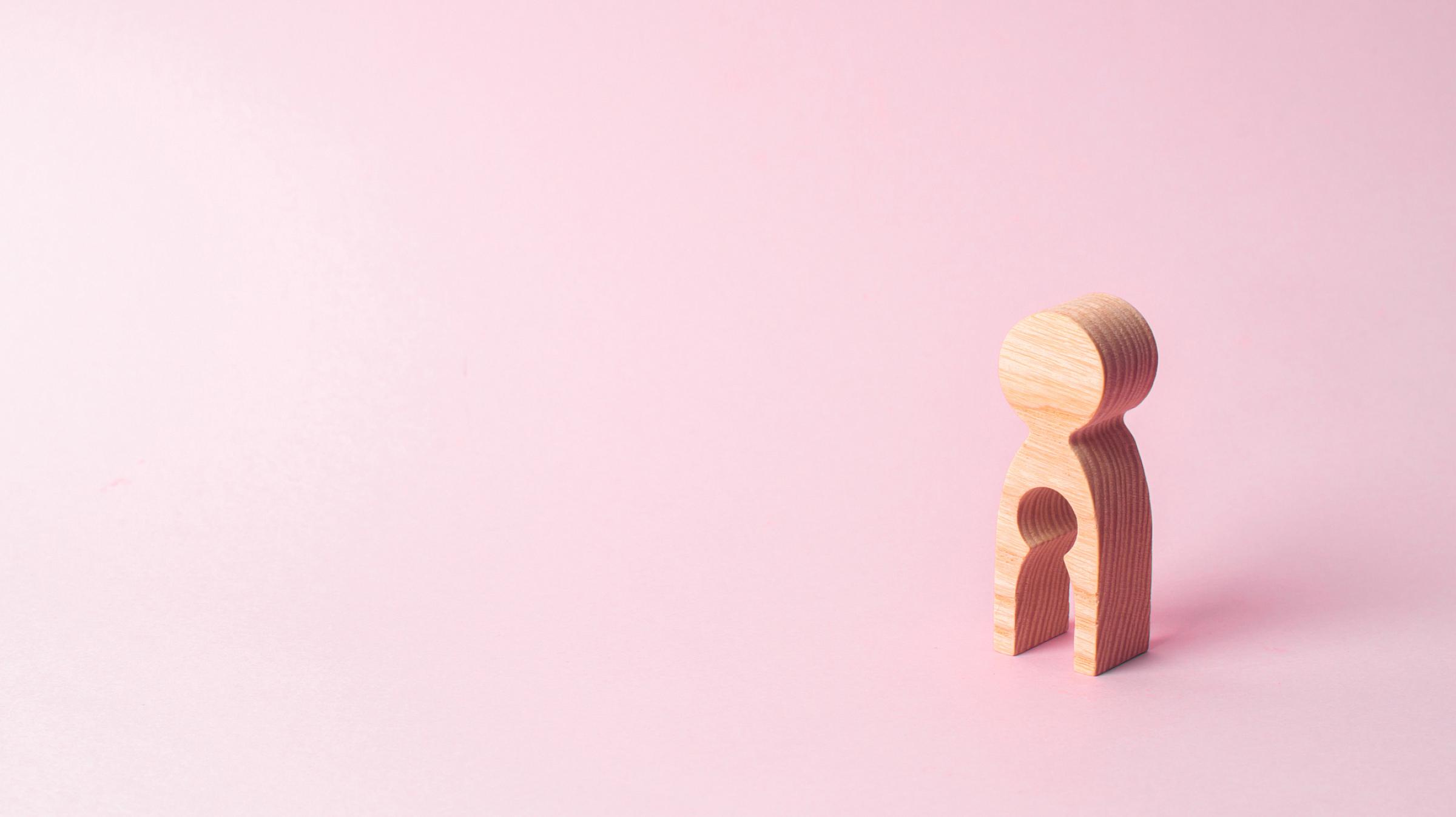 Wooden carve out of figure on pink background