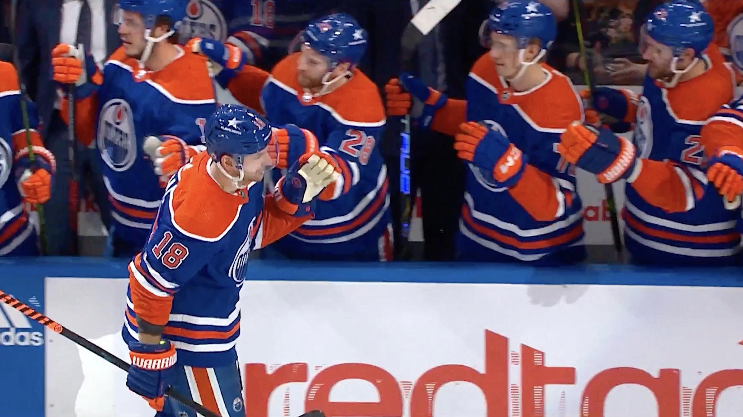 NHL hockey player skating past teammates and giving high fives