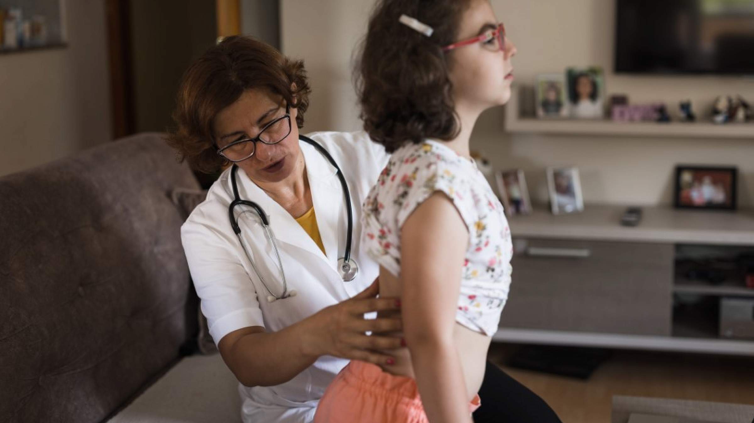 Female doctor examines a girl's back
