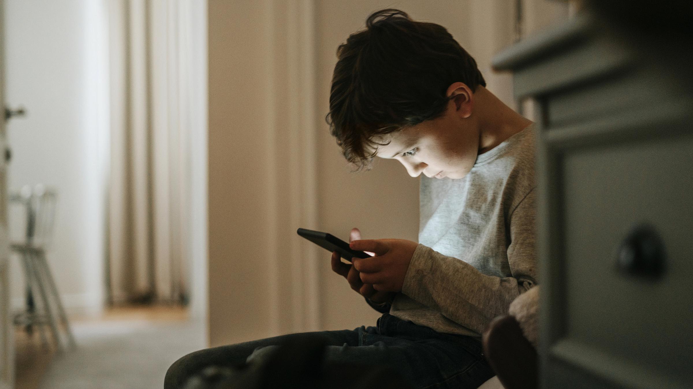 School age child looking at smart phone
