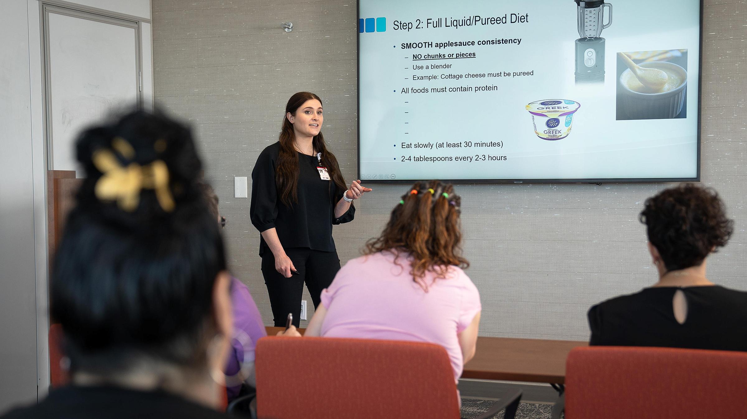 Weight loss educator presents dietary information to a class