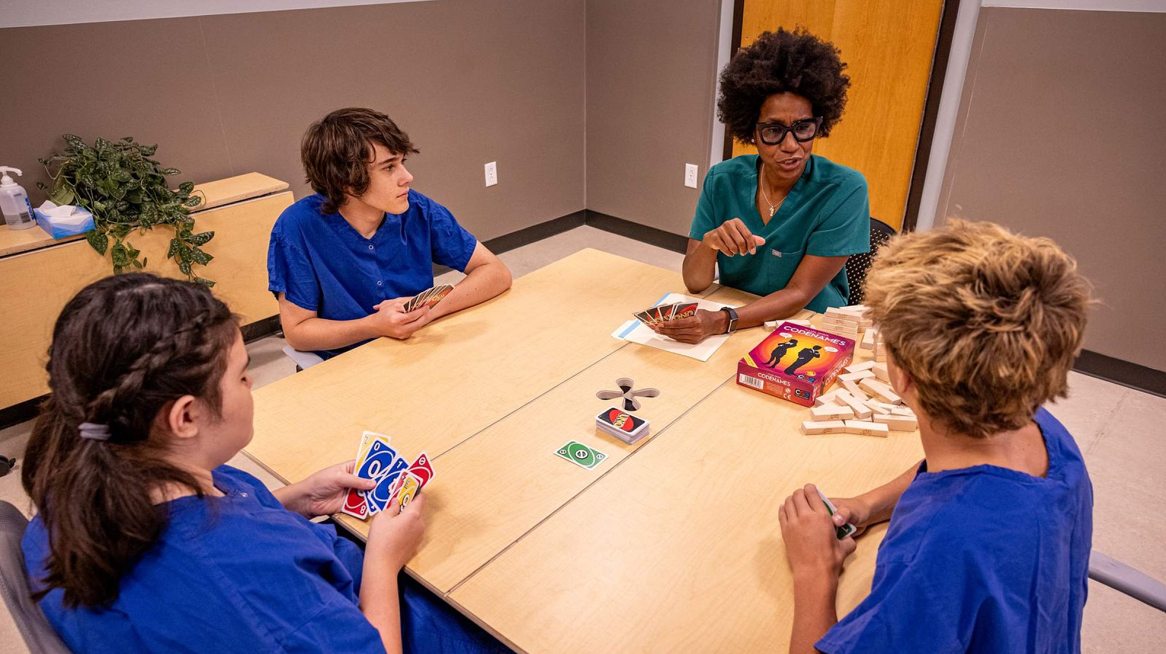 doctor playing card games with three youths