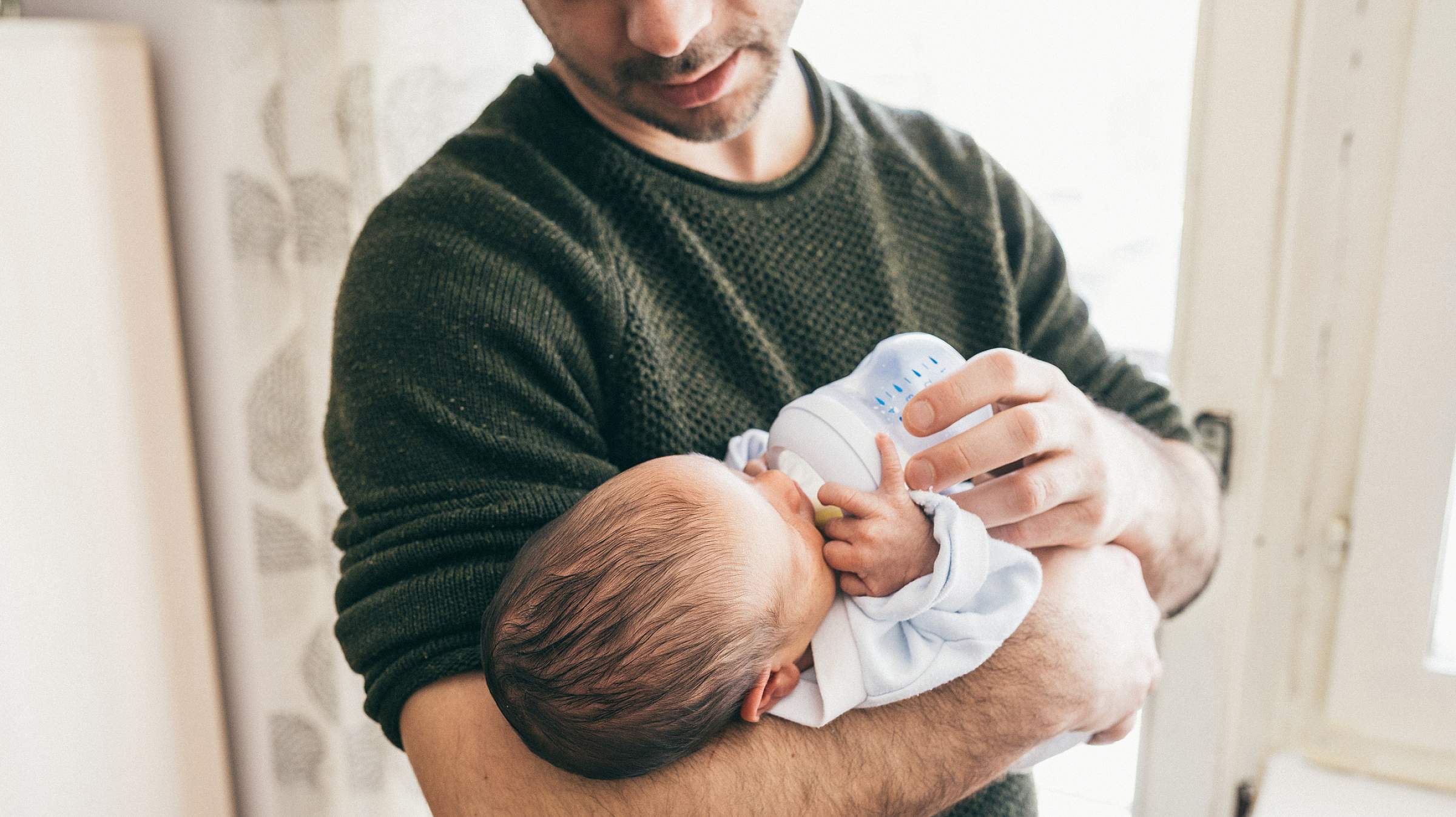 Man holding infant with bottle