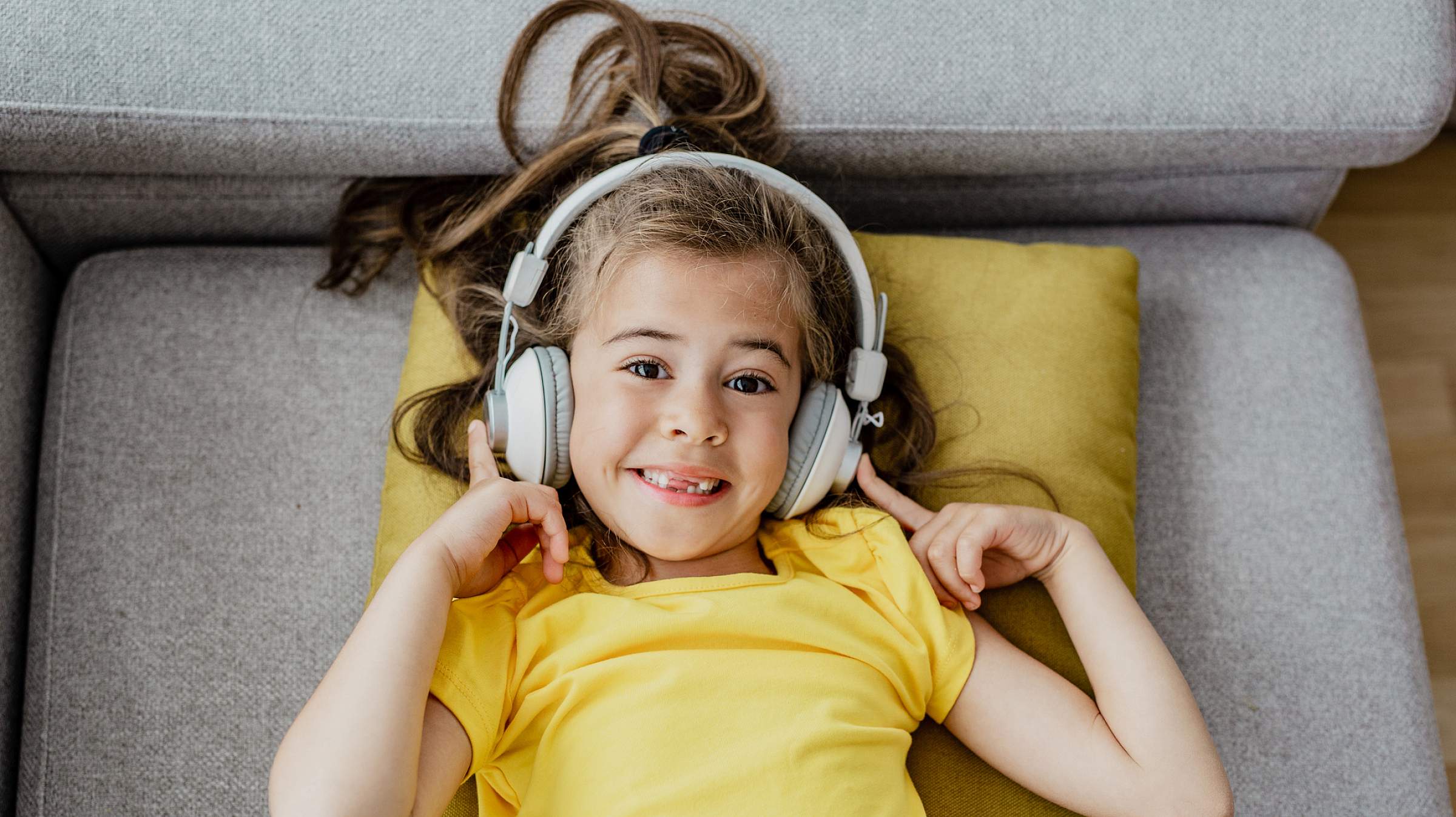 Child in yellow with white headphones