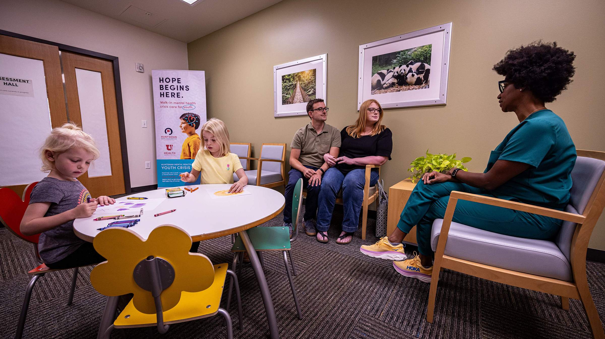 Parents consulting with a doctor while children engage in drawing activities at the Youth Crisis Care center